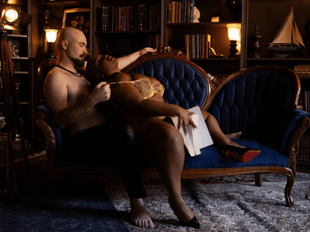 Couple relaxing together on a blue velvet sofa during a couples boudoir photography session in Evansville, Indiana.