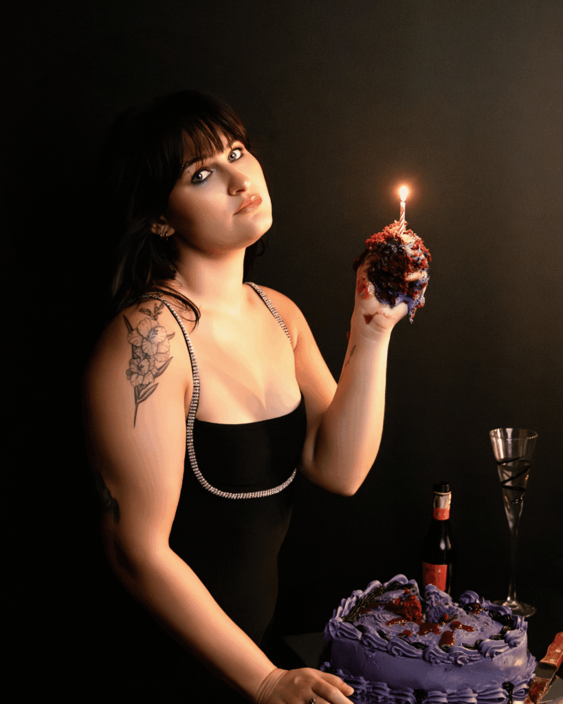 Woman holding a birthday cake during a celebration boudoir session in Evansville, Indiana.