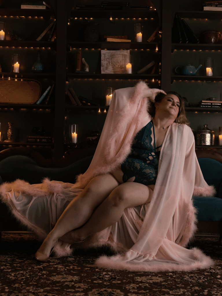 Woman wearing blue lace lingerie and a blush pink robe during a luxury boudoir photography session at Boudoir with Jewels in Evansville, Indiana.